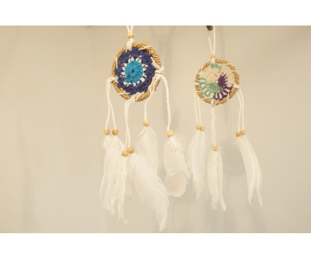 8530130 Dreamcatcher. Mini dreamcatcher mix. 6 x blauw/lichtblauw/groen 6 cm. diameter en 6 x donkerblauw met rand van touw en witte veren. Lengte +/- 25 cm. Per 12 stuks verpakt. Prijs is per 12 stuks.