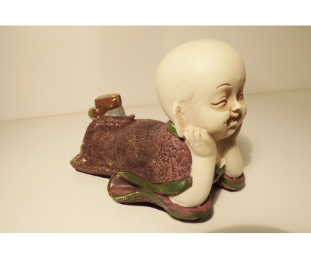 P1035822 Poly. Liggende, denkend paarse baby monk 17 x 10 cm.