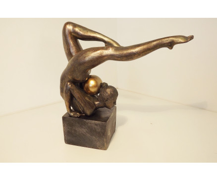 P1035829 Poly. Vrouwelijk turnster in balans met gouden bal in haar nek Op rechthoekige basis. LxBxH : 25x9x25 cm.