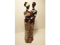 P1035182 Poly Africa. Afrikaans stel in traditionele kledij en sieraden in innige omhelzing. Kleding is ingezet met spiegeltjes. 34 cm. hoog.